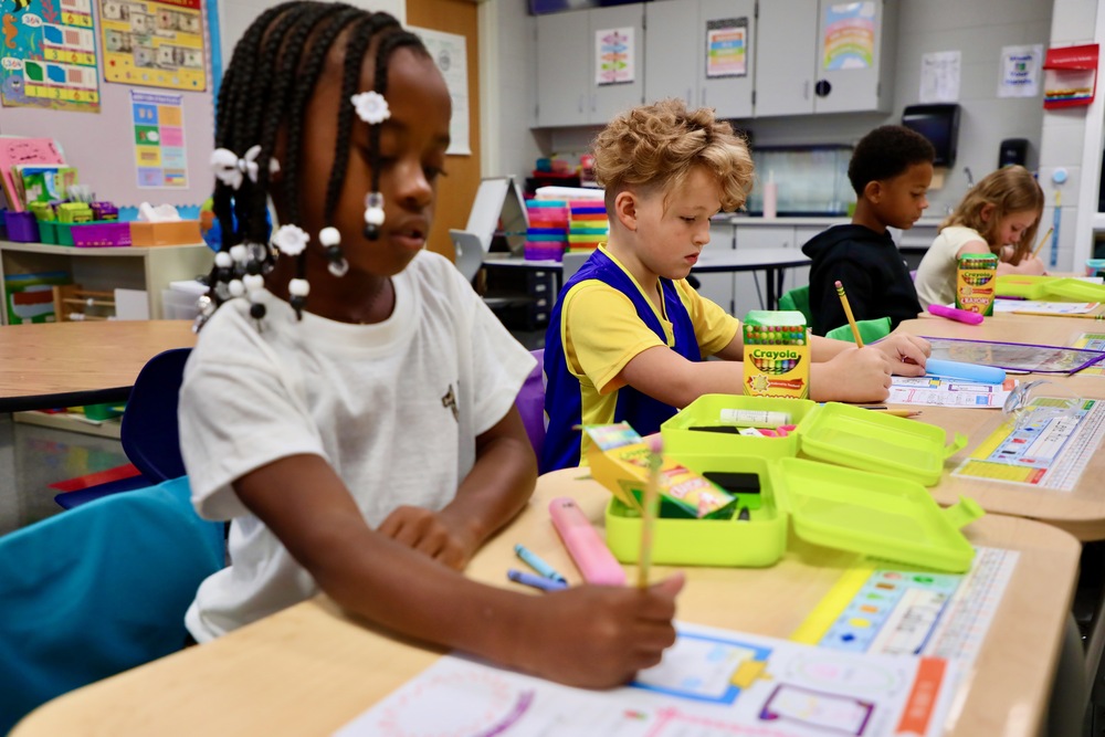 Students color a picture in their classroom