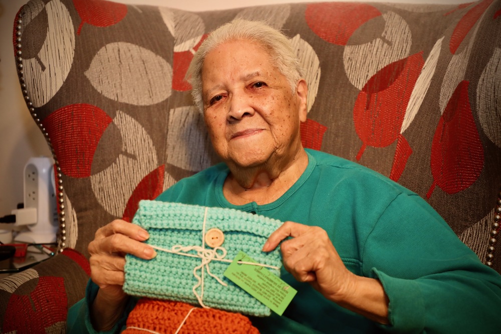 Una Peterson holds one of her hand-crocheted pencil pouches