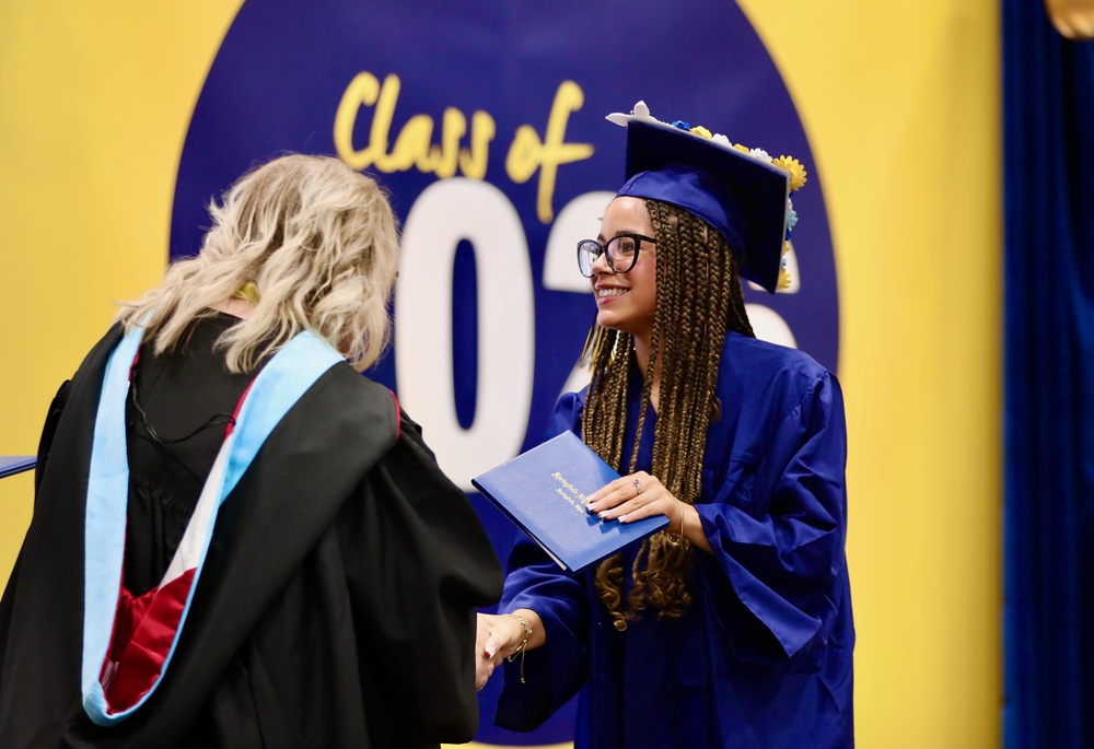 A graduate receives their diploma