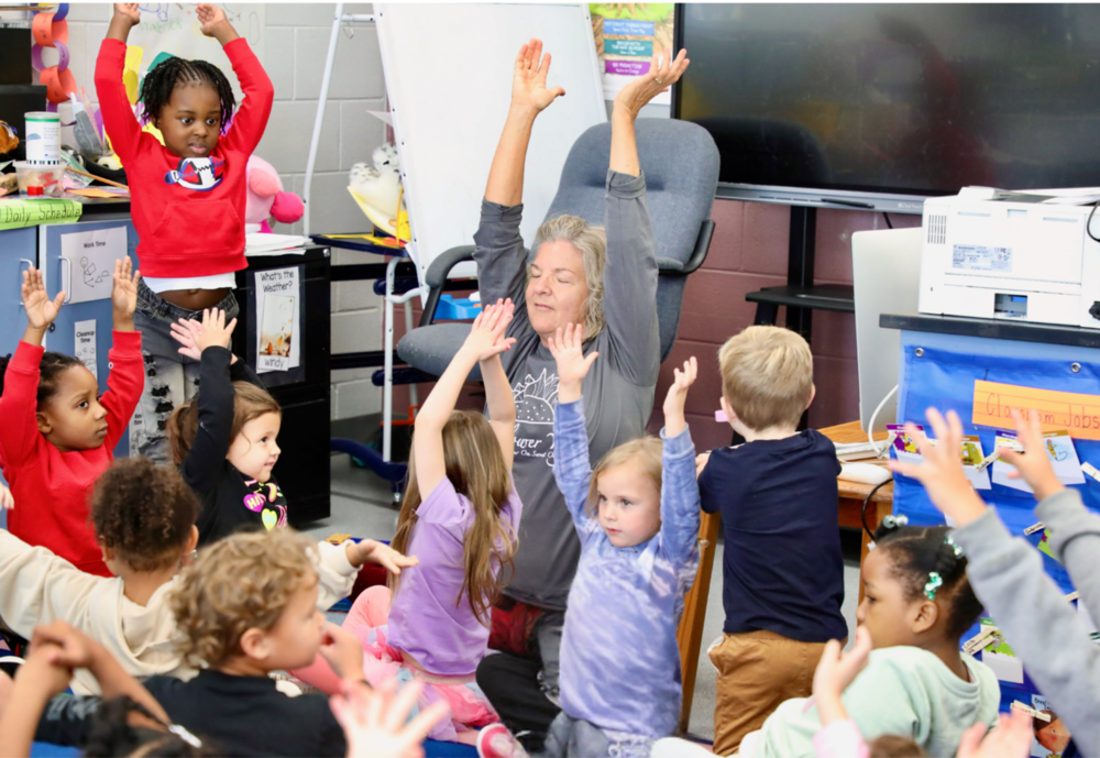 Clark preschool students stretch their arms to the sky during a mini yoga session