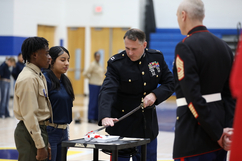 Two cadets help to cut the ceremonial cake