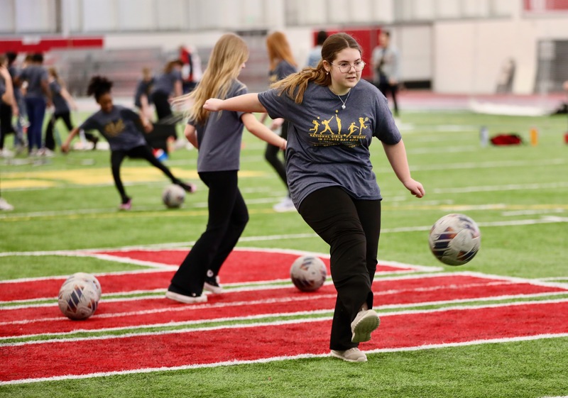 A student kicks a soccer ball to the goal