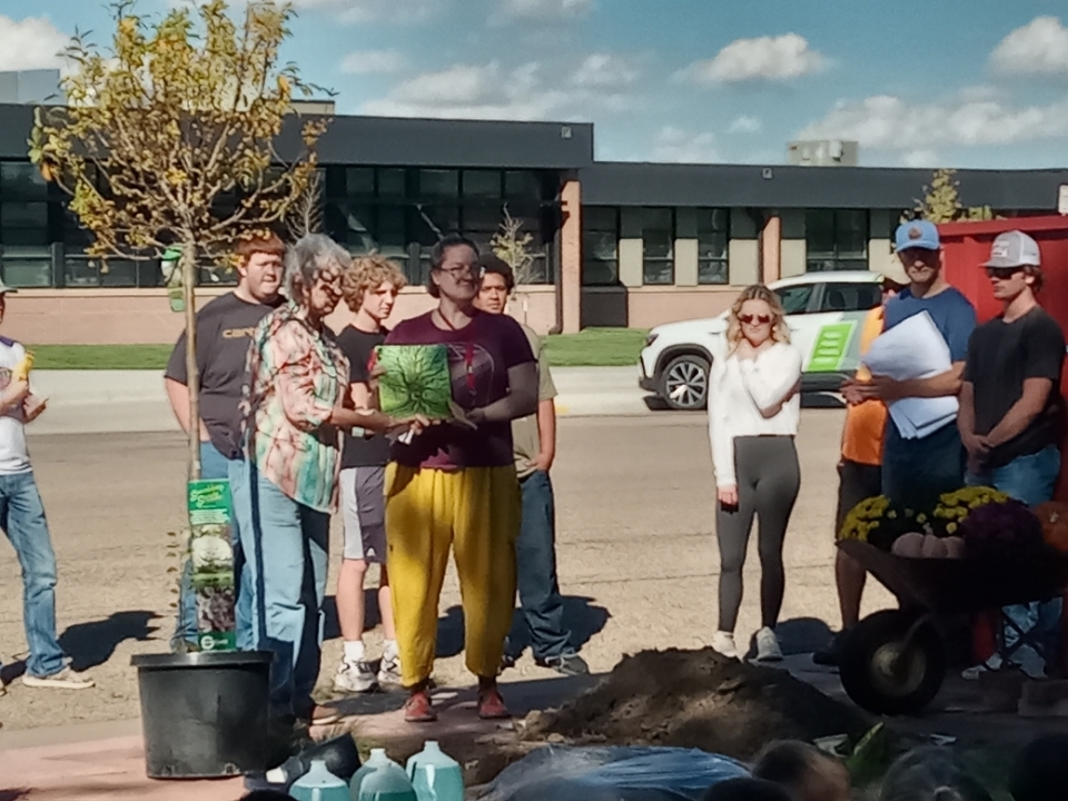 School Librarian, Roxann Hall, is presented with the book "Trees".