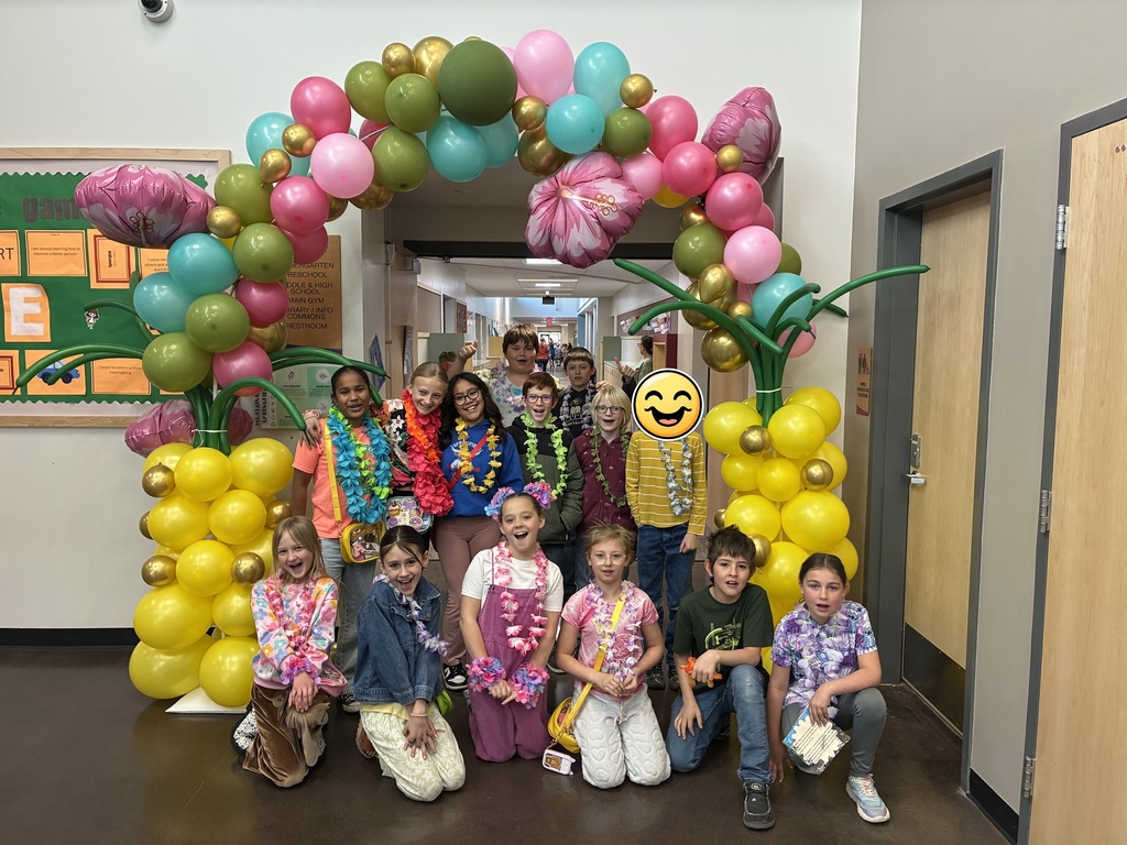 Picture of students with Hawaiian backdrop for 100th day of school