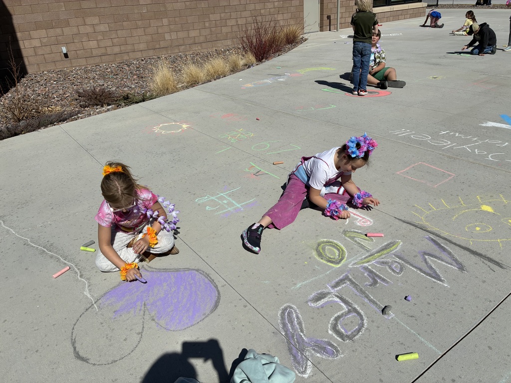 Picture of students drawing with chalk on sidewalk