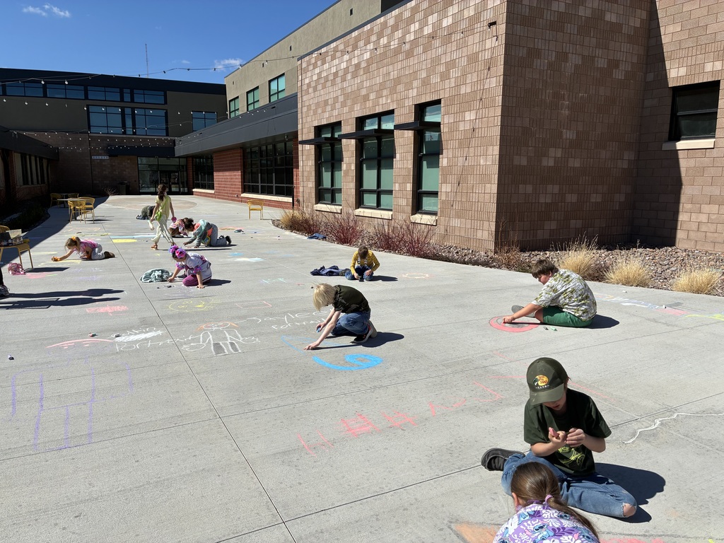 Picture of students drawing with chalk on sidewalk