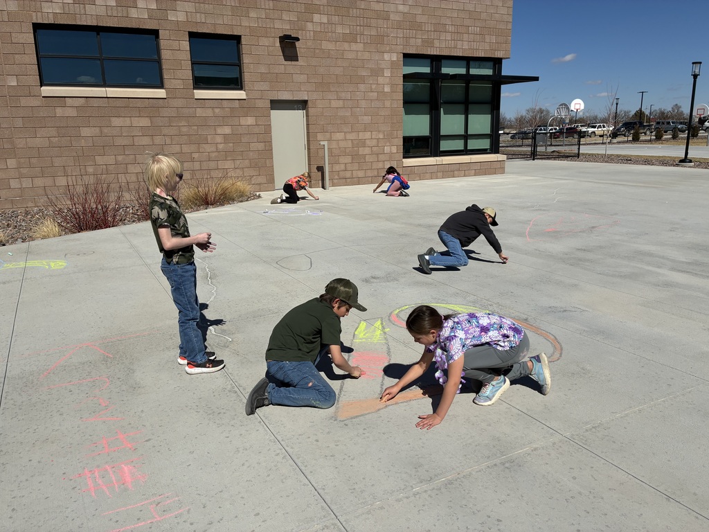 Picture of students drawing with chalk on sidewalk