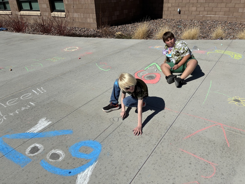 Picture of students drawing with chalk on sidewalk