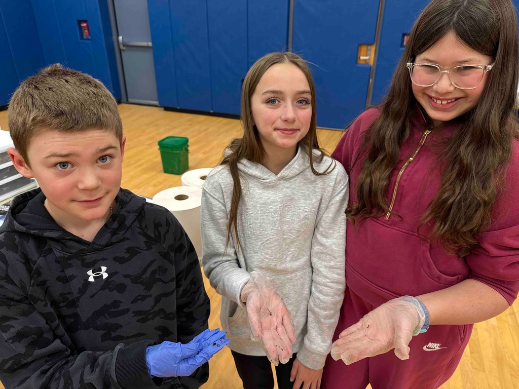 students hold up worms