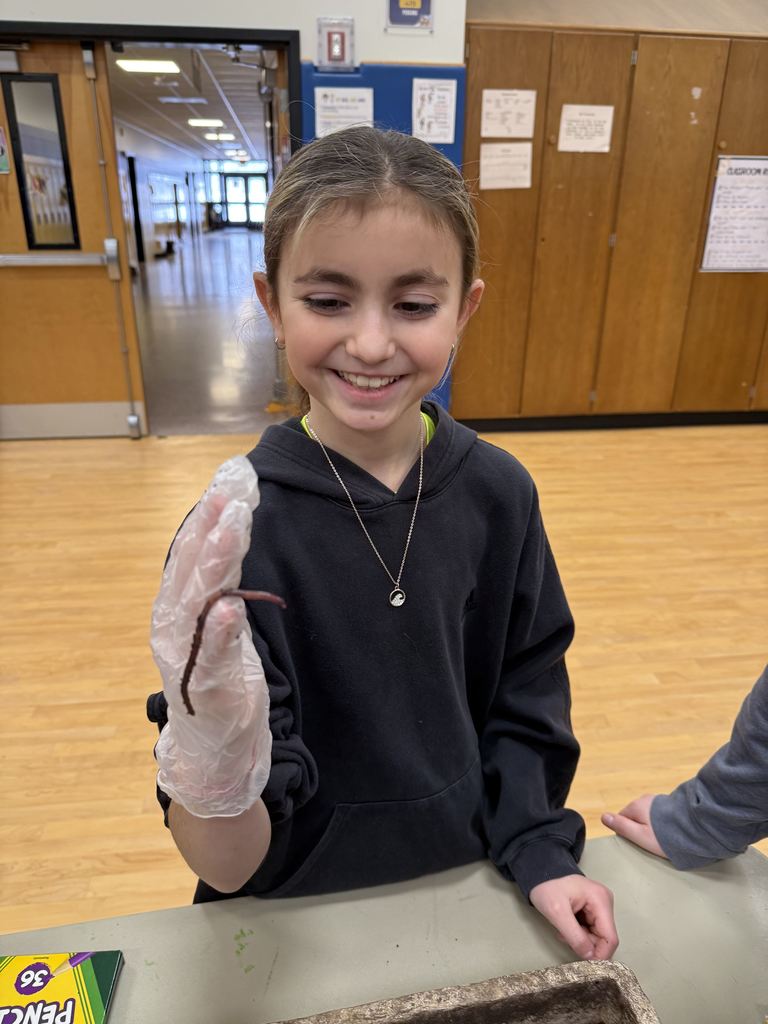 students hold up worms