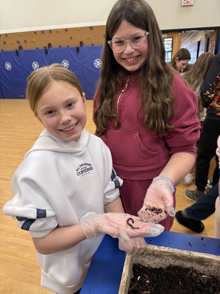 students hold up worms