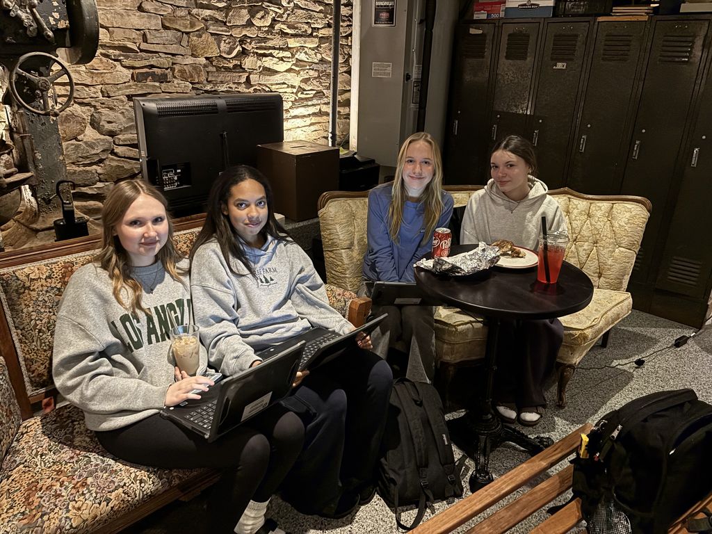 students work on the yearbook in a cafe.