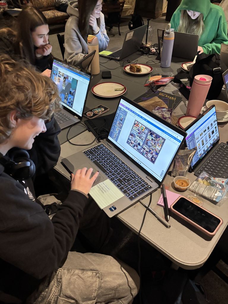 students work on the yearbook in a cafe.