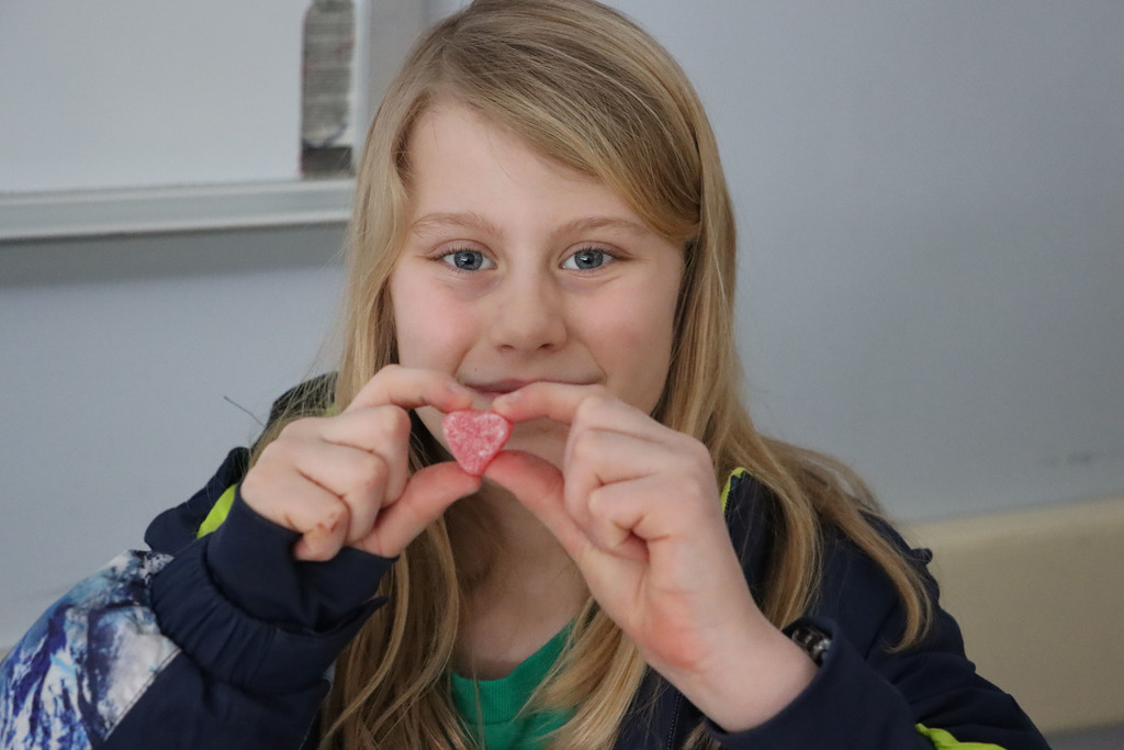a student holds up a heart candy.