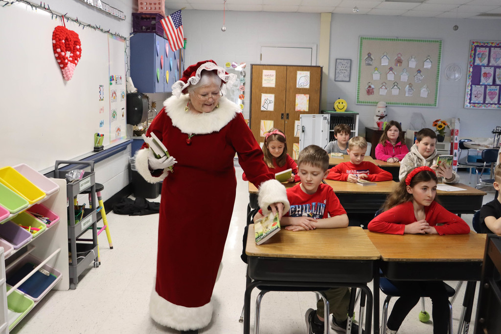 Mrs. Claus hands out books.