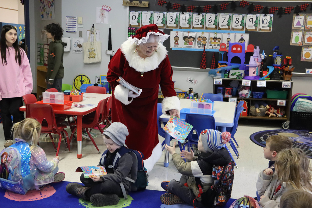Mrs. Claus hands out books.