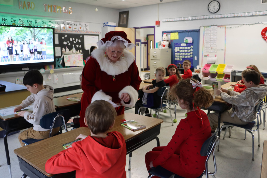 Mrs. Claus hands out bookmarks. 