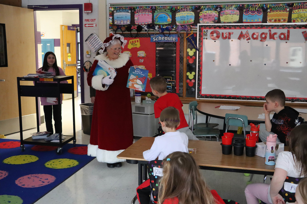 Mrs. Claus hands out books.