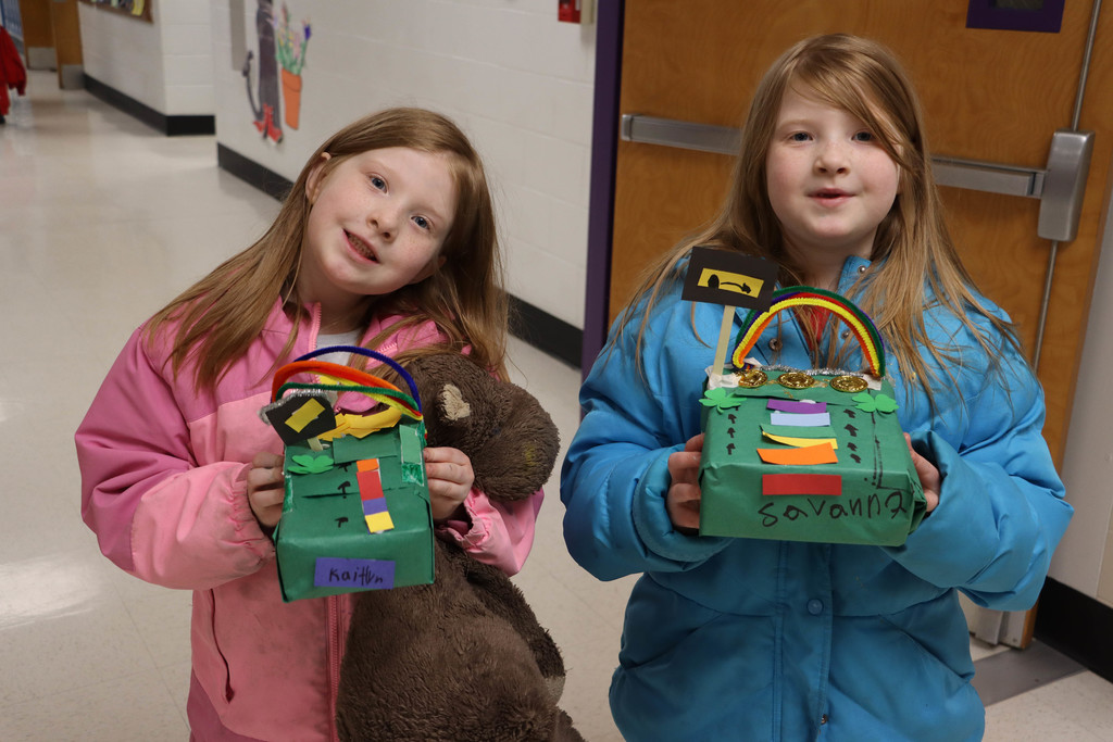 Two students hold leprechaun houses