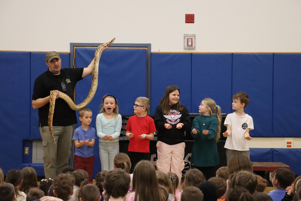 students line up to hold a snake