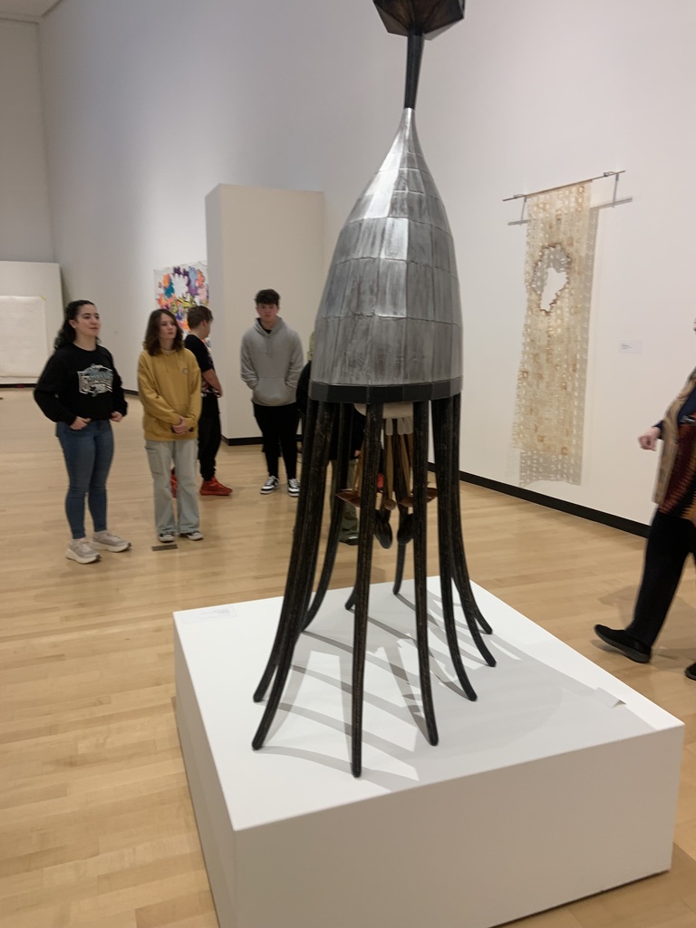 Student look at a sculpture. 