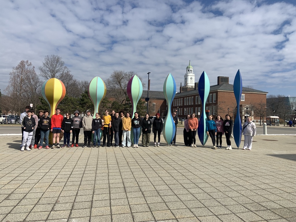 Students pose near sculptures outside the museum. 