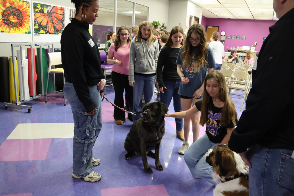 Students pet the dog.