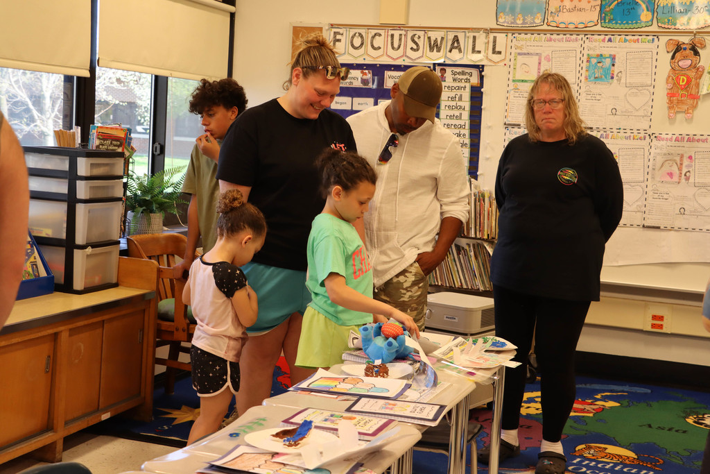 A student shows her classwork to her family. 