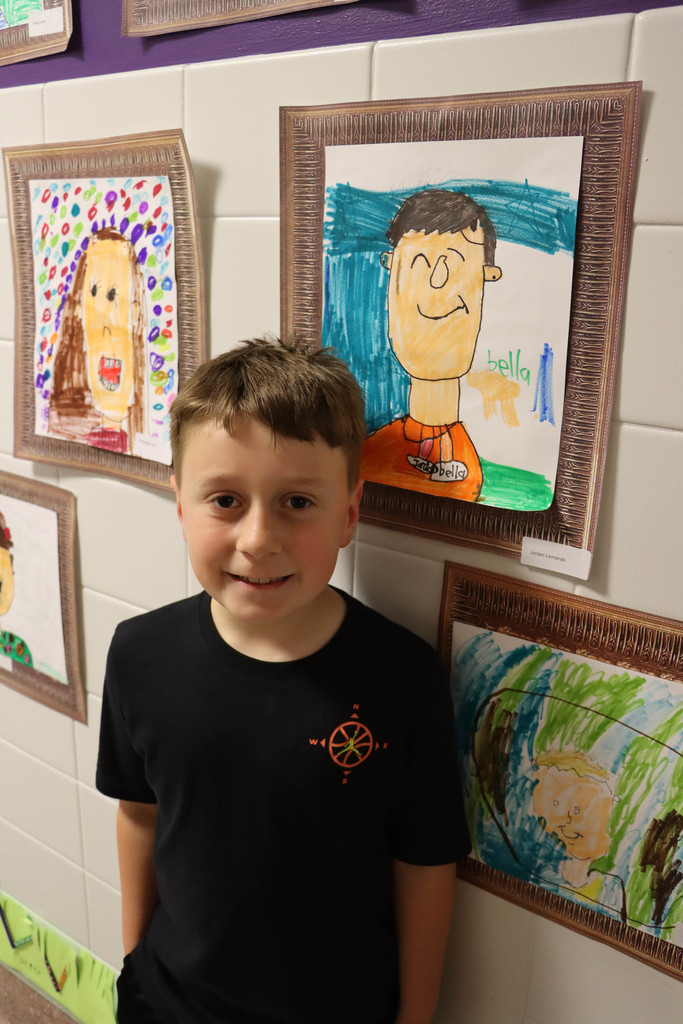 A student poses with his self protrait.