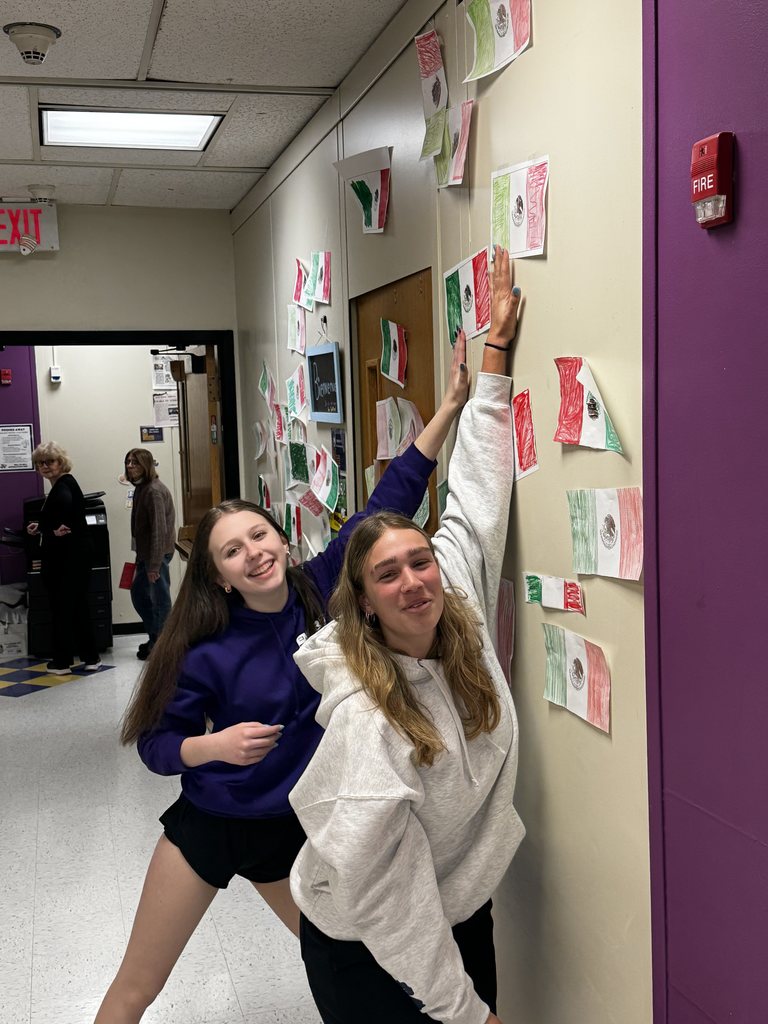Two students hang up the Mexican flag during the flag war. 