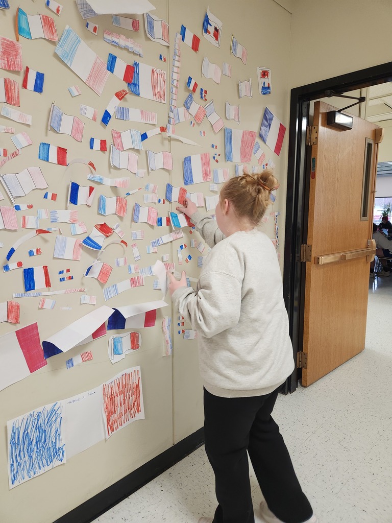 A student hangs up French flags for the flag war. 