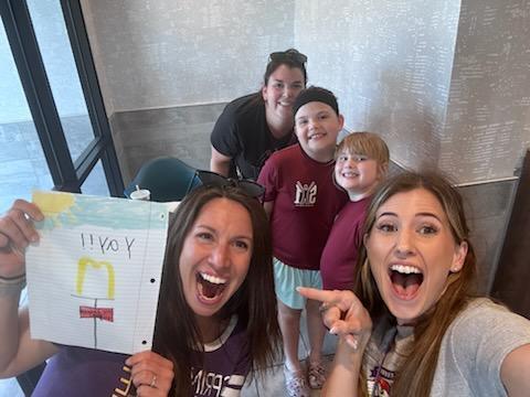 Teachers and family with a drawing.