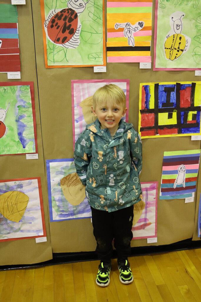 A student stands with his artwork. 