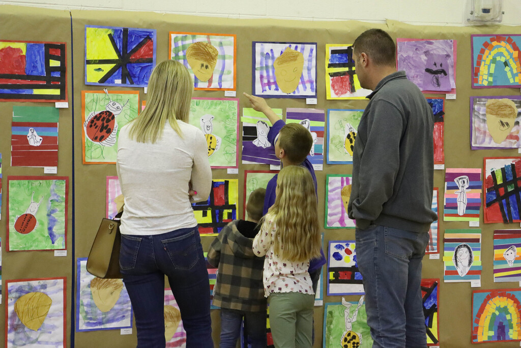 A student points to art in the gym.