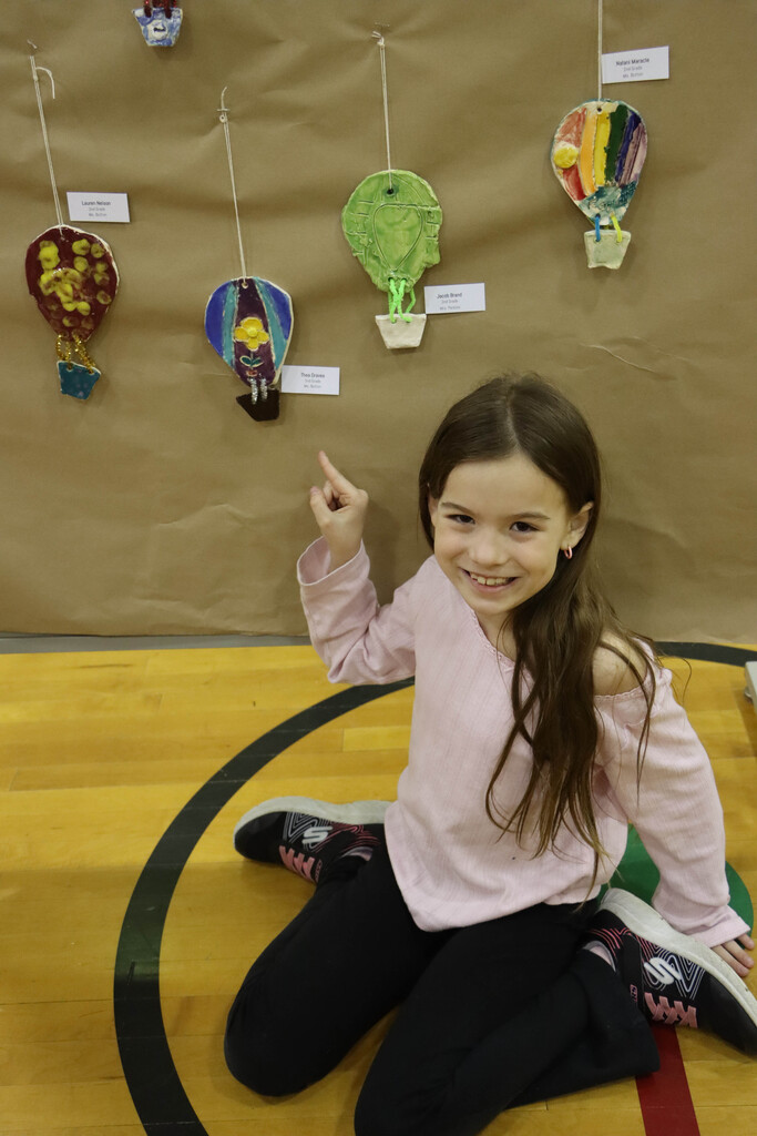 A student points to her artwork.