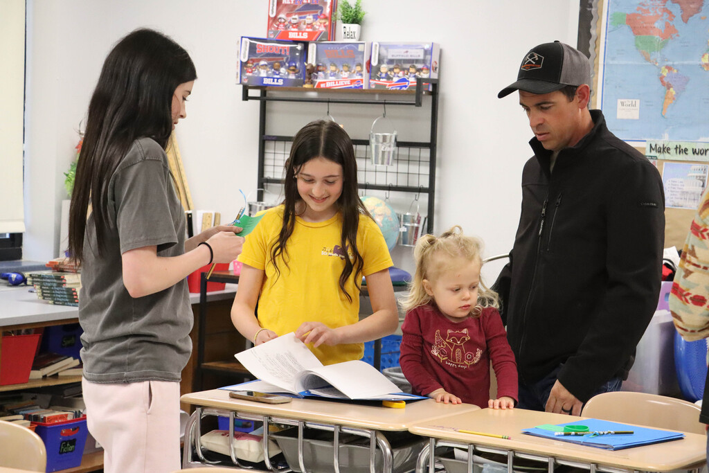 A family looks at their student's classroom projects. 