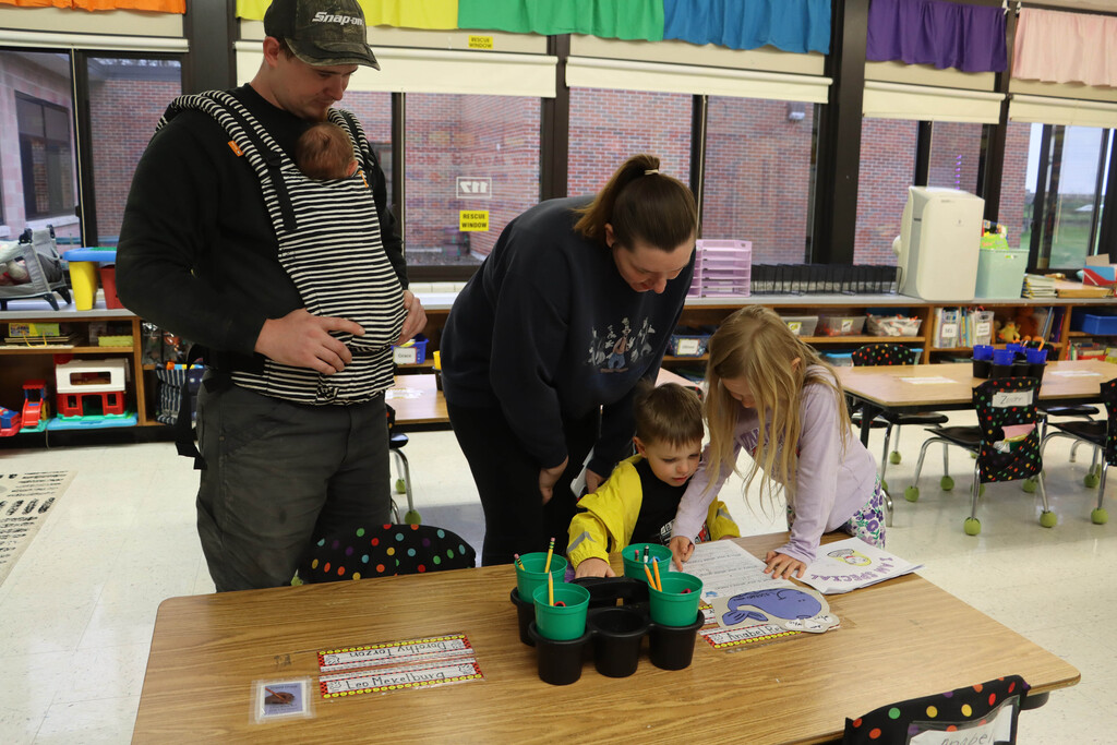 A family looks at their student's classroom projects. 