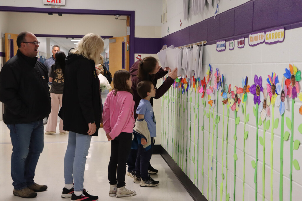 A family looks at projects in the hallway.