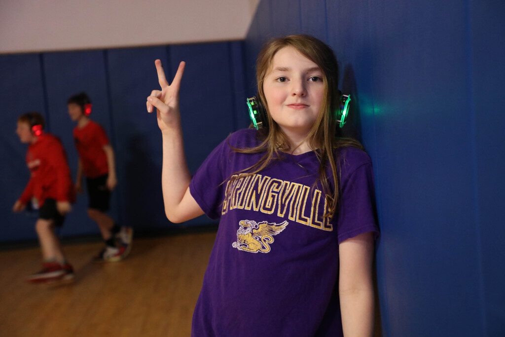 A student makes a peace sign while listening to the silent disco music. 
