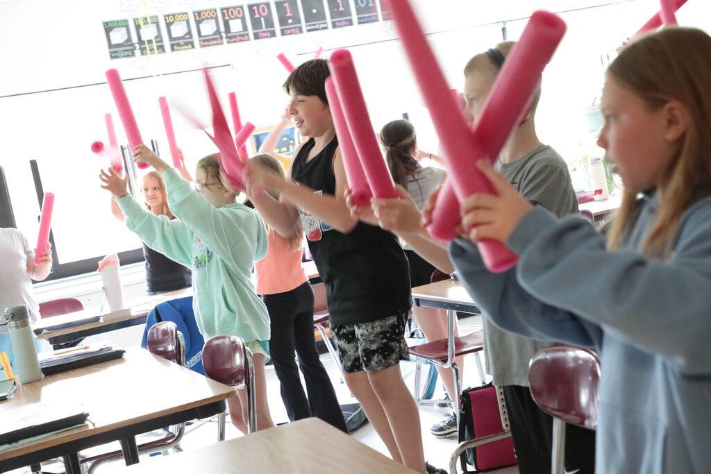 Students use foam noodles to exercise.