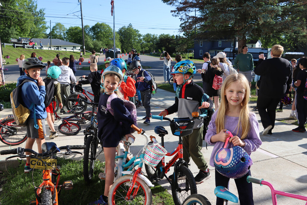 Students smile while parking their bikes. 