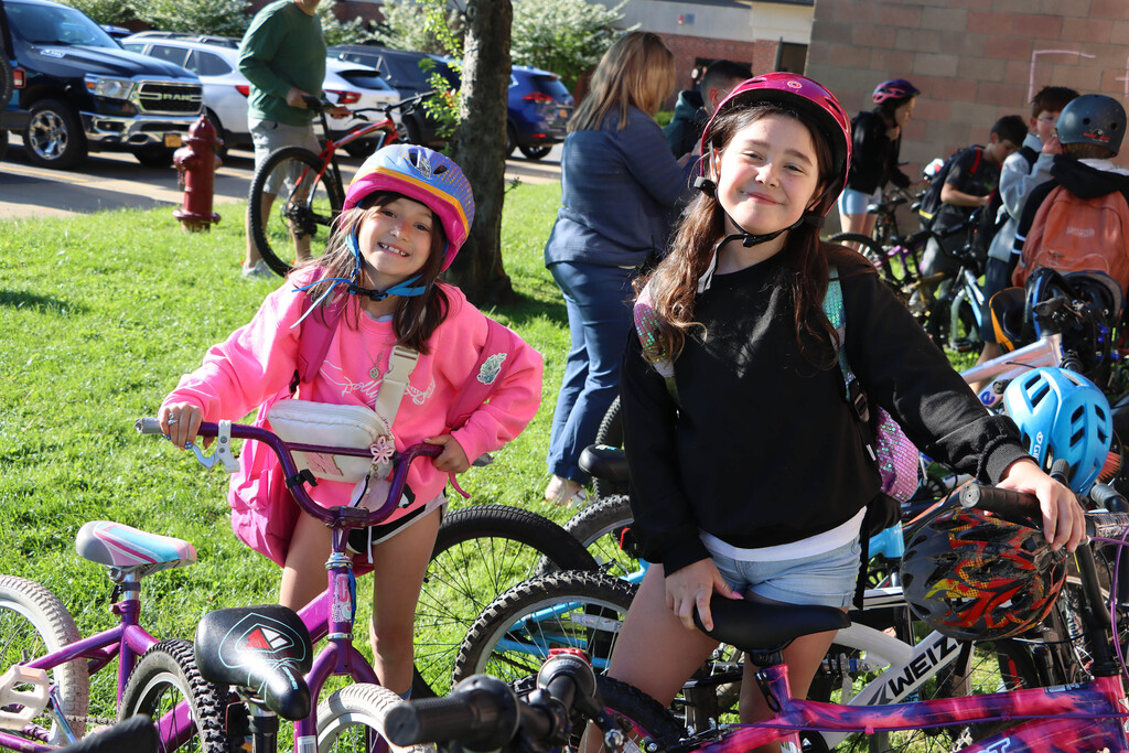 Students smile while parking their bikes. 