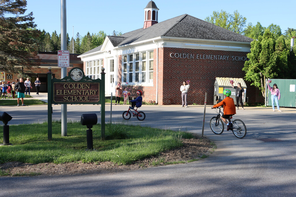 Students ride their bikes in the school bus loop. 