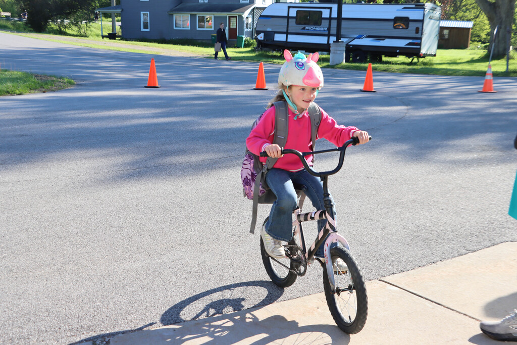 A student pulls into the school on her bike. 