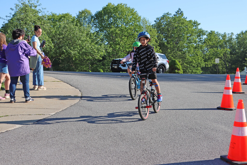 Students bike into the school parking lot. 