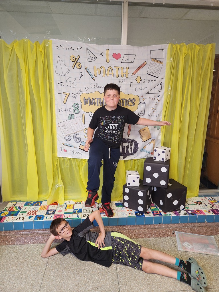 Two boys in front of the Math Night Poster.