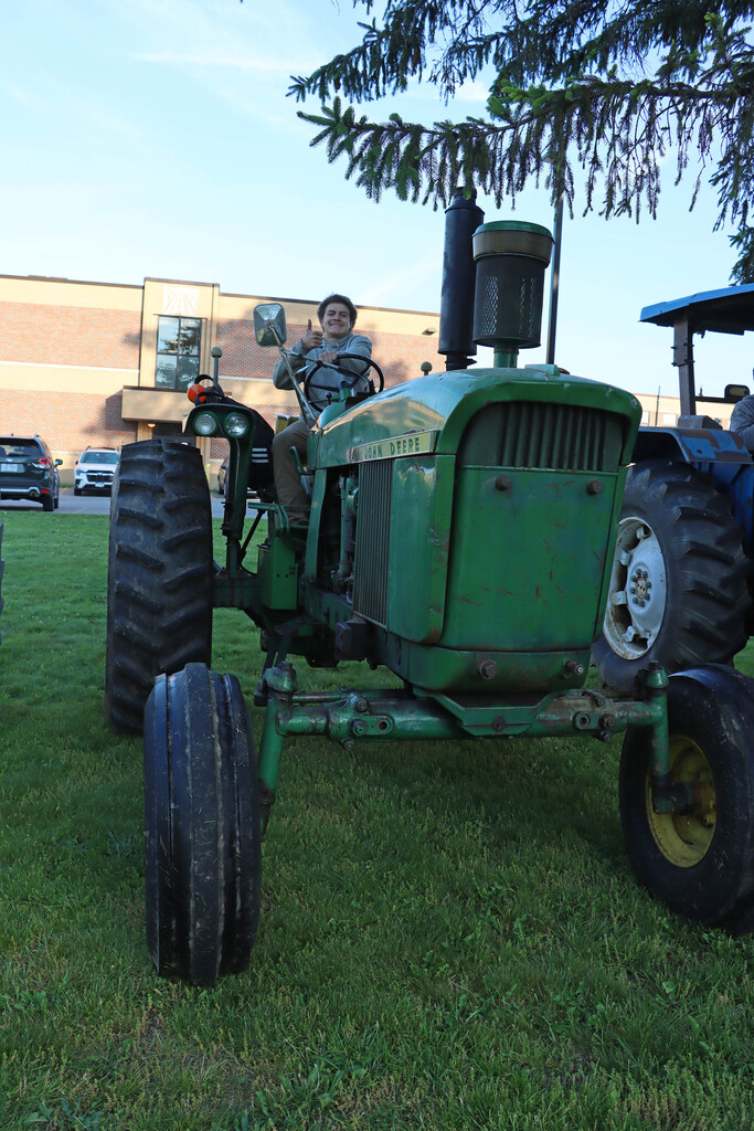Student on green tractor