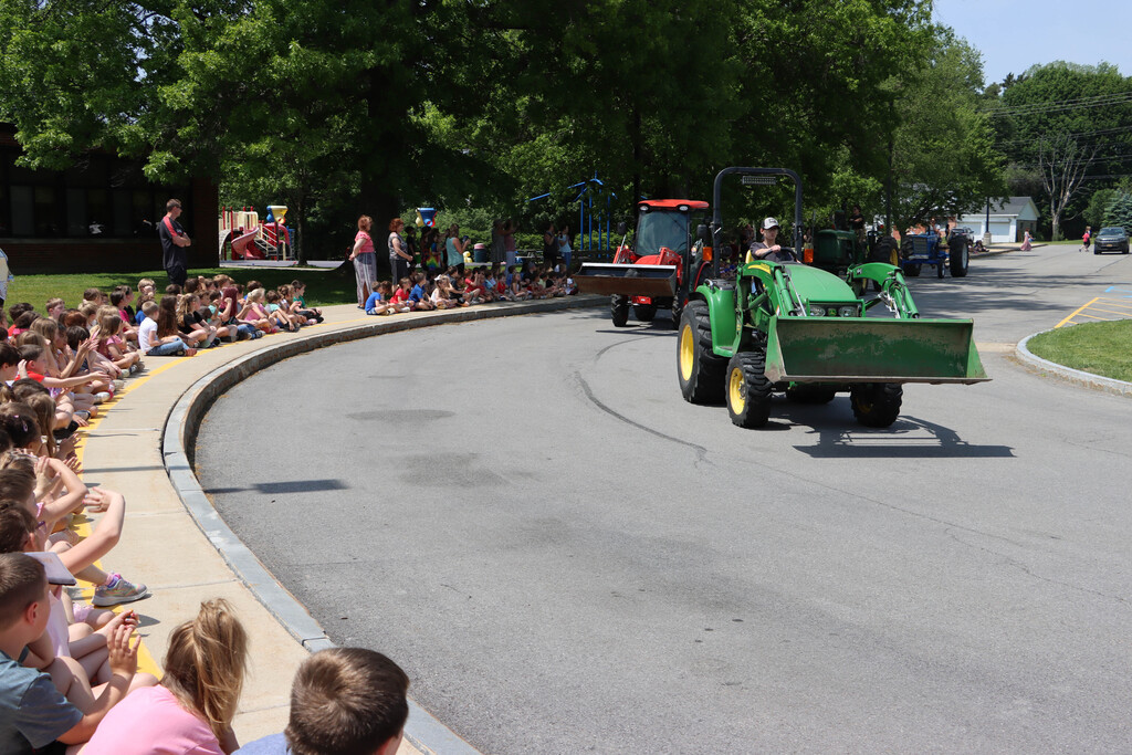 students on tractors drive by SES students