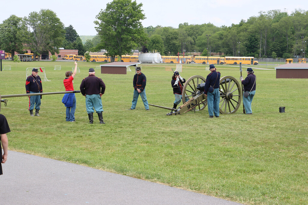 Student raises hand to signal the cannon firing. 