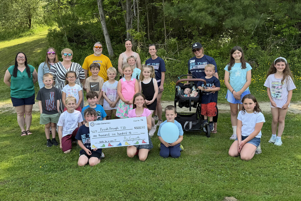 Students, staff and volunteer with the $1600 check